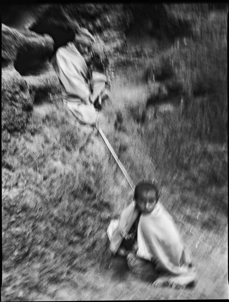 Photographie argentique en noir et blanc d'un prêtre et d'un enfant assis dans la nature à Lalibela/Ethiopie.
