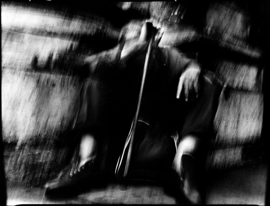 Photographie argentique en noir et blanc d'un homme prostré, assis par terre sur le parvis de l'église Saint-Paul à Paris.