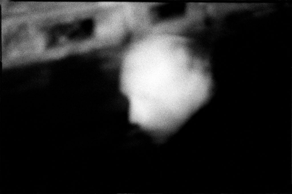 Photographie argentique en noir et blanc d'une tête blanche d'homme dans une rue à Paris.