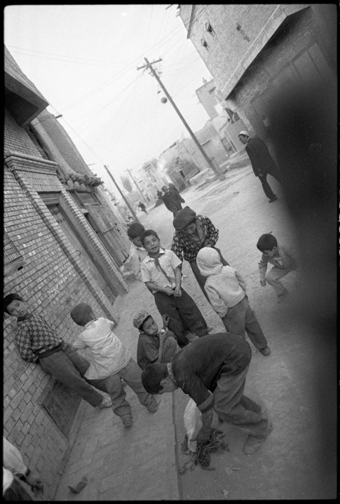 Photographie argentique en noir et blanc d'un groupe de jeunes garçons ouïgours dans une rue de Kashgar/Chine.